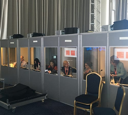 Interpreters at work in soundproof booths backstage at Xerox event in Portugal